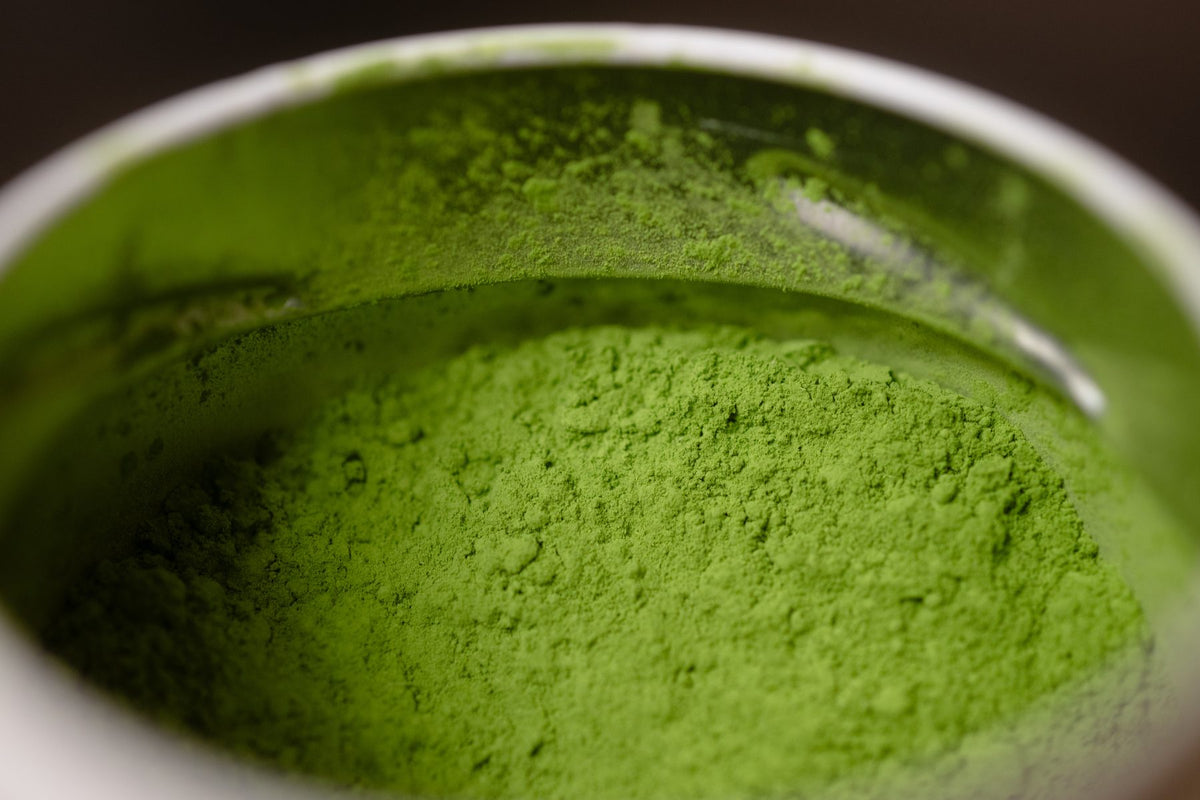 Stone ground matcha powder in a ceramic bowl, seen close